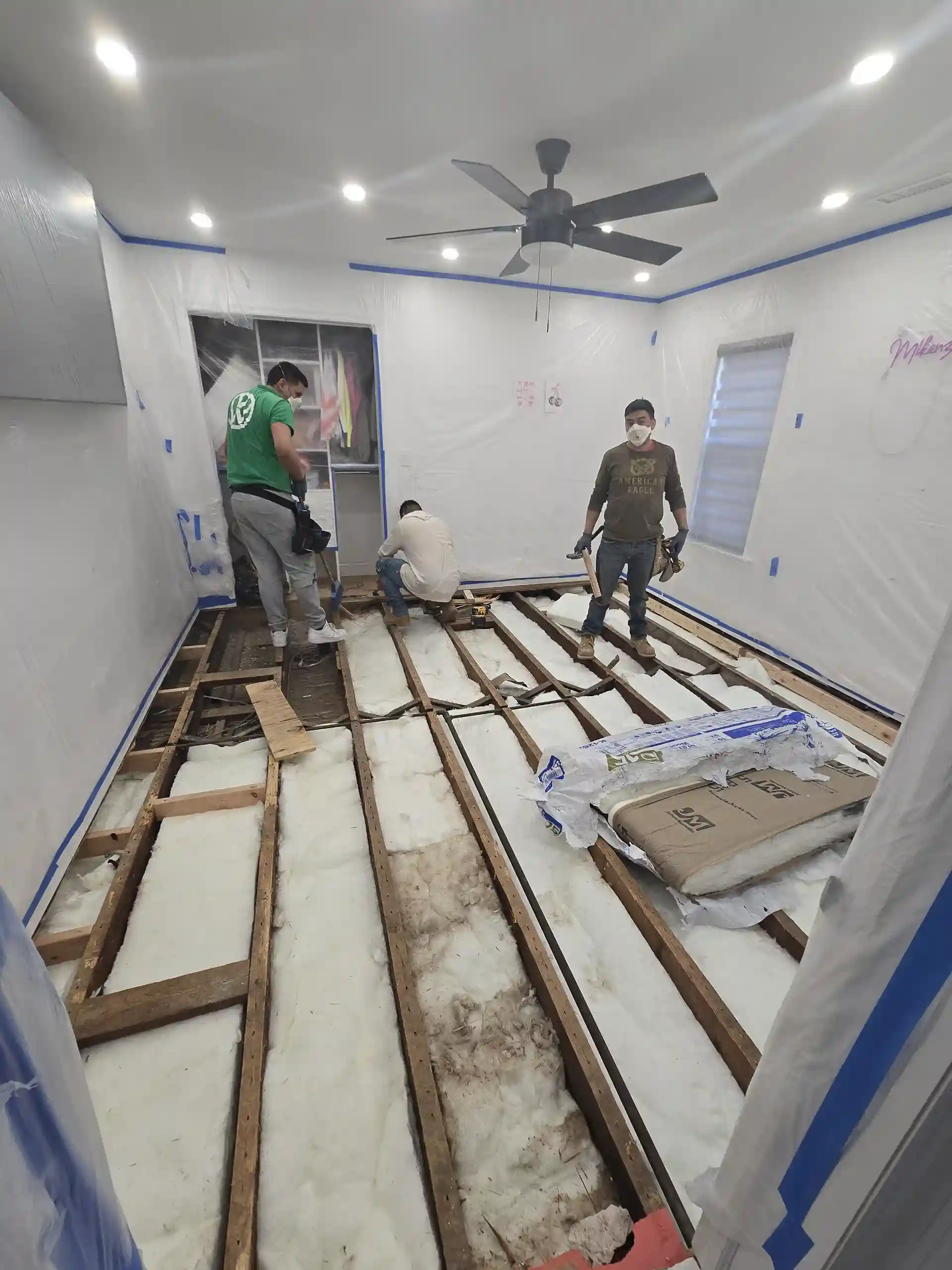 Workers installing floor insulation during a home renovation in Brooklyn NY