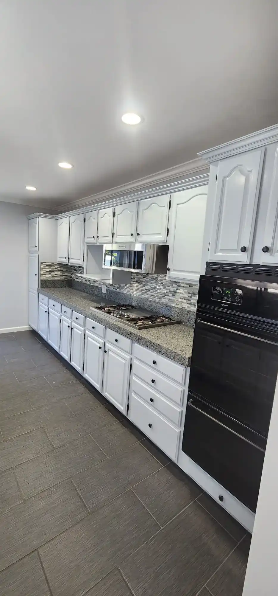 Full kitchen renovation with white cabinets, granite counters and tile floor in Brooklyn NY