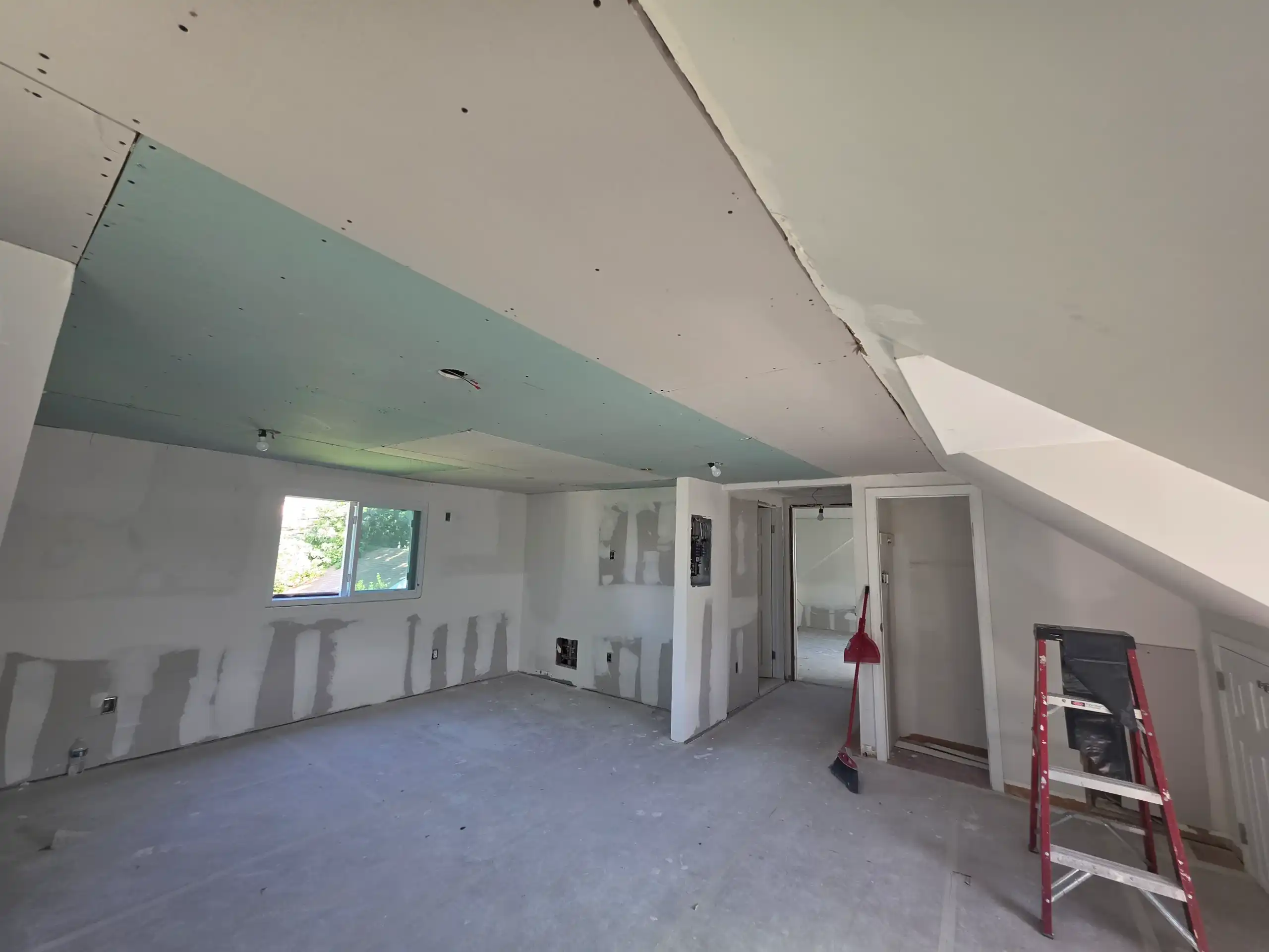 Interior room under renovation with new drywall, mudded walls and ceiling in Brooklyn home