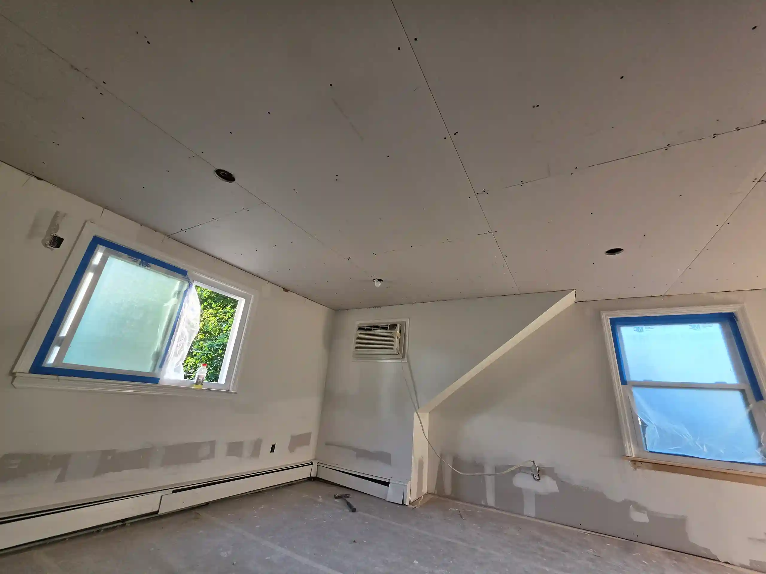 Interior room renovation with new drywall, taped seams and installed windows in Brooklyn