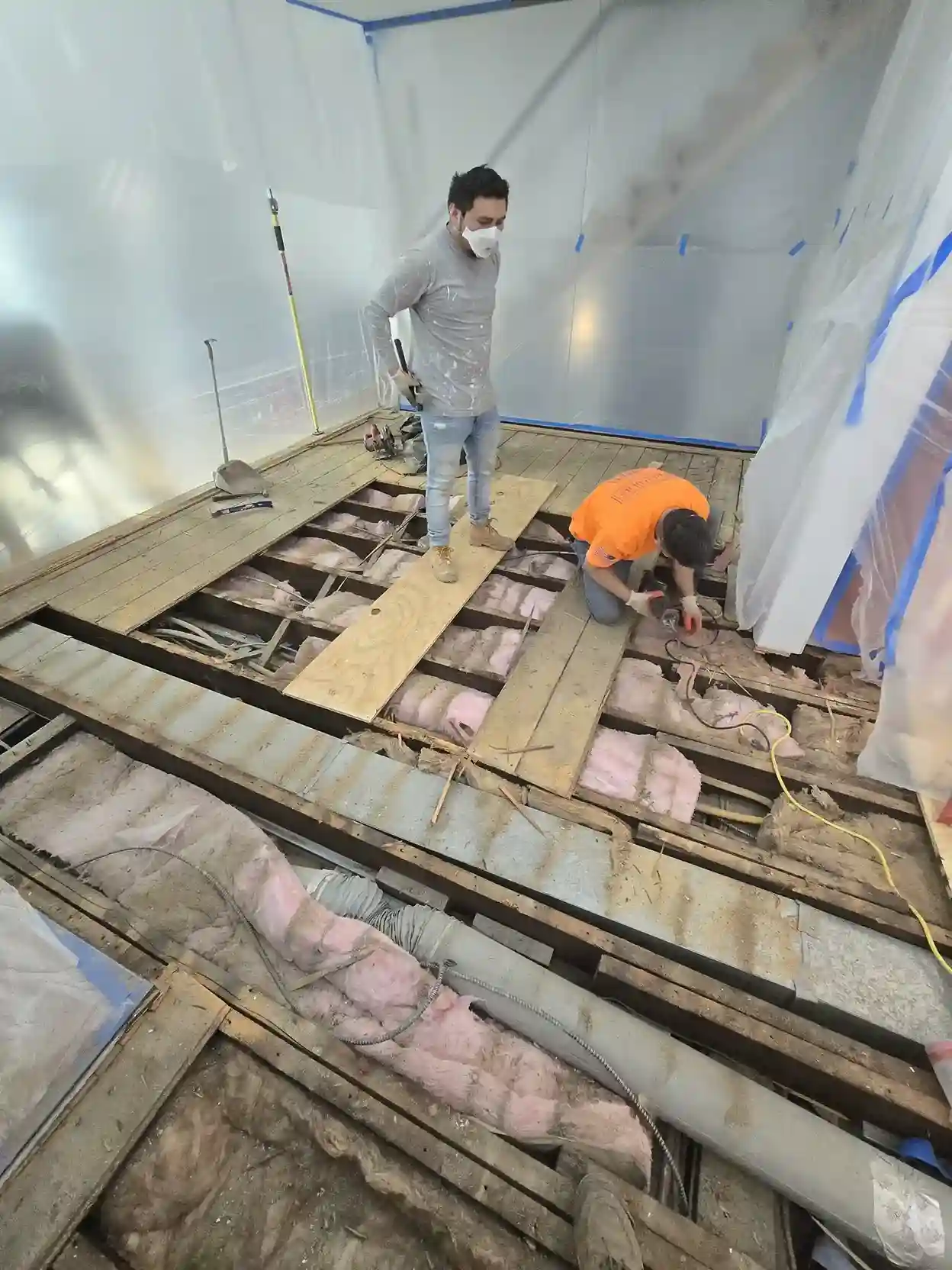 Interior home renovation with workers replacing subfloor during remodeling in Brooklyn NY