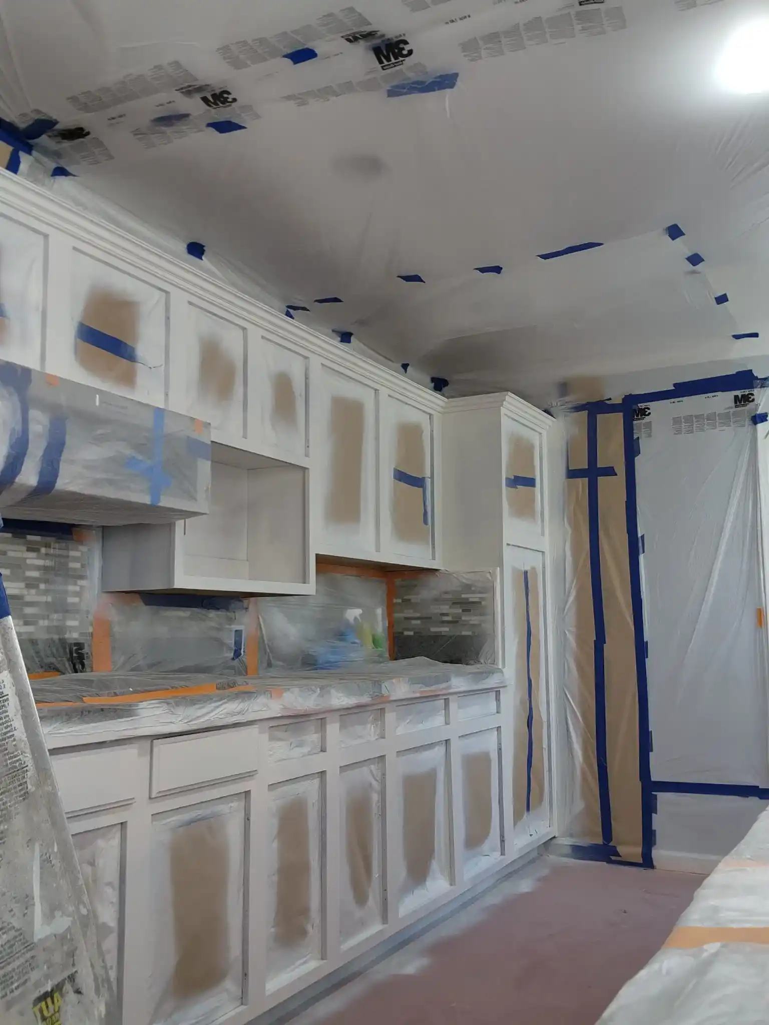 Kitchen cabinet painting renovation in progress with masked cabinets in Brooklyn home
