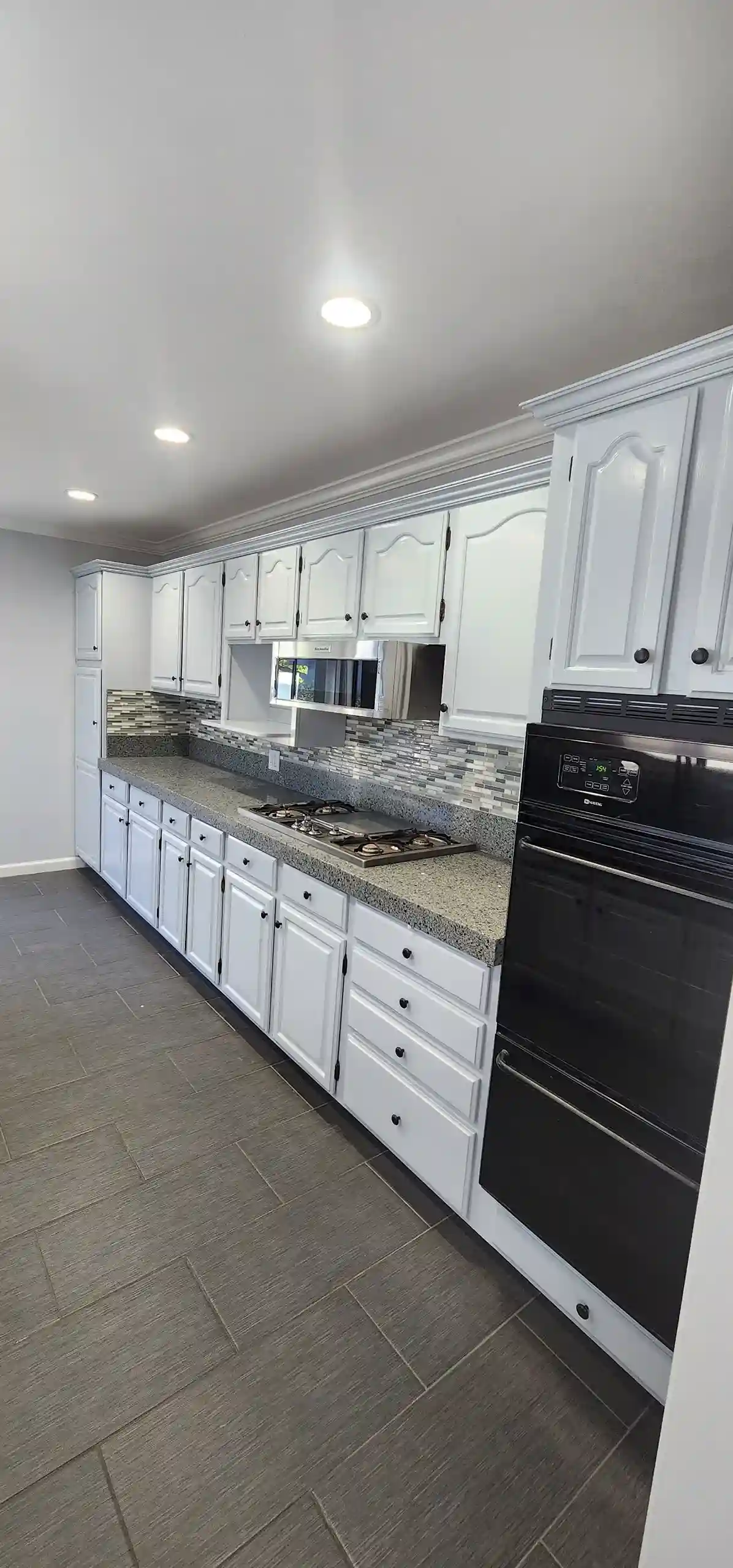 Modern renovated kitchen with white cabinets, granite countertops and tile backsplash in Brooklyn NY