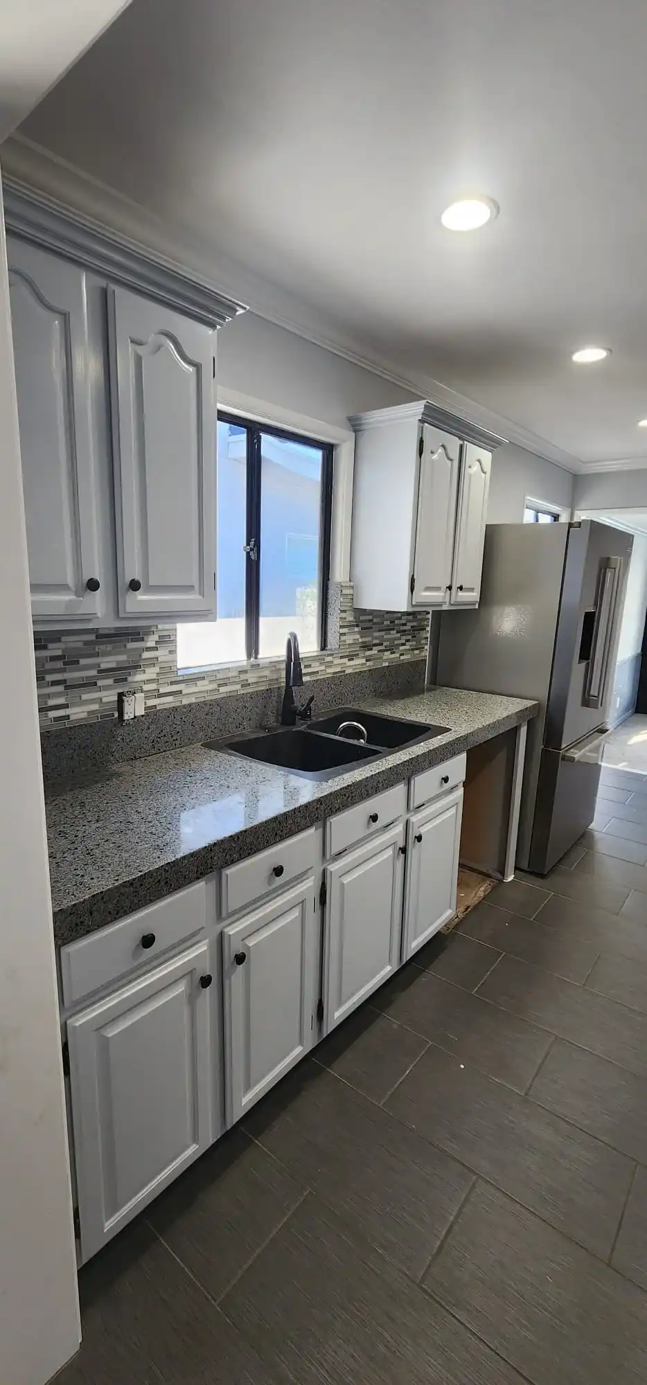 Modern white kitchen renovation with granite counters, tile backsplash and double sink in Brooklyn NY
