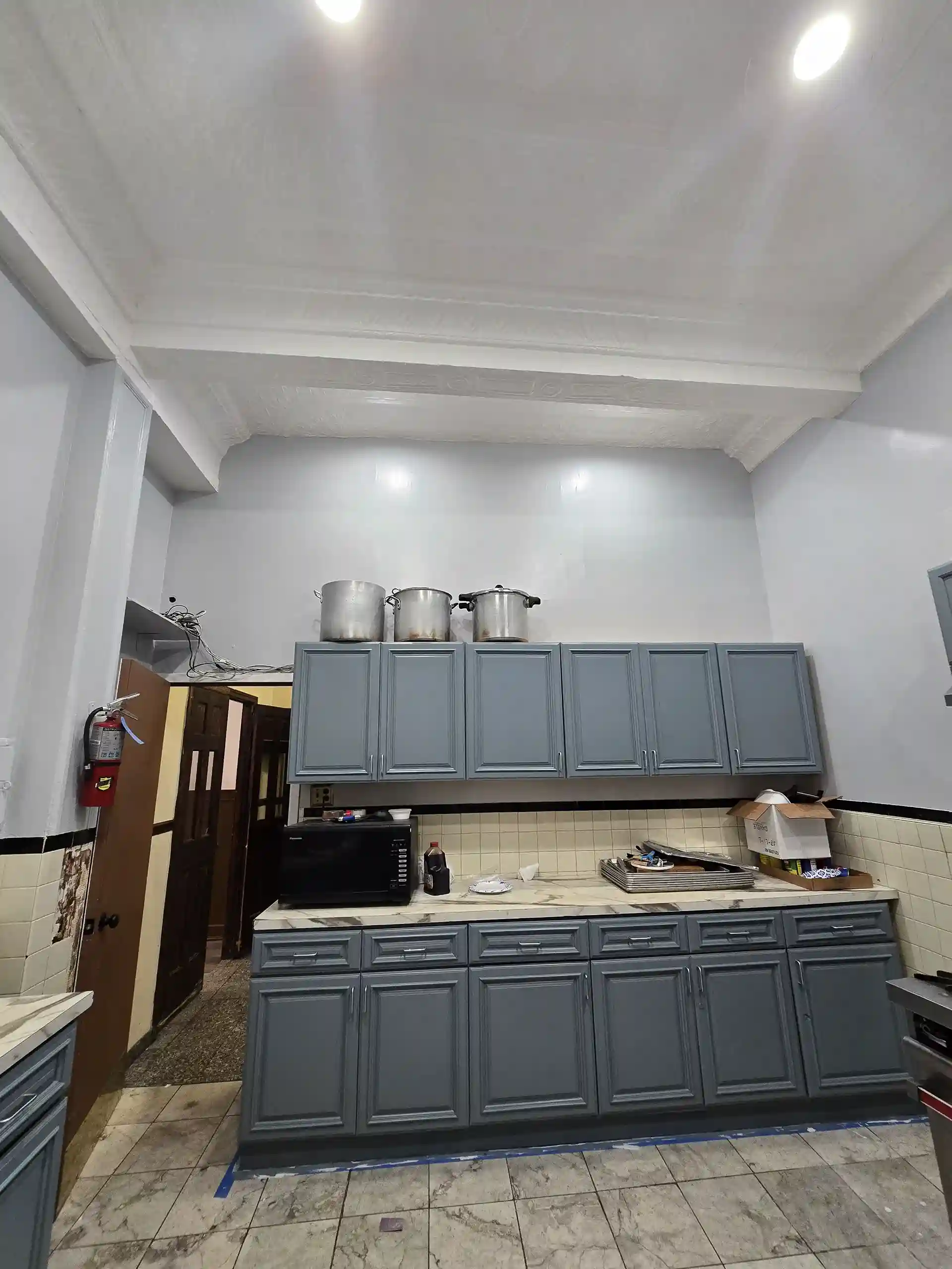 Renovated kitchen with gray cabinets, marble countertops and tile flooring in Brooklyn home