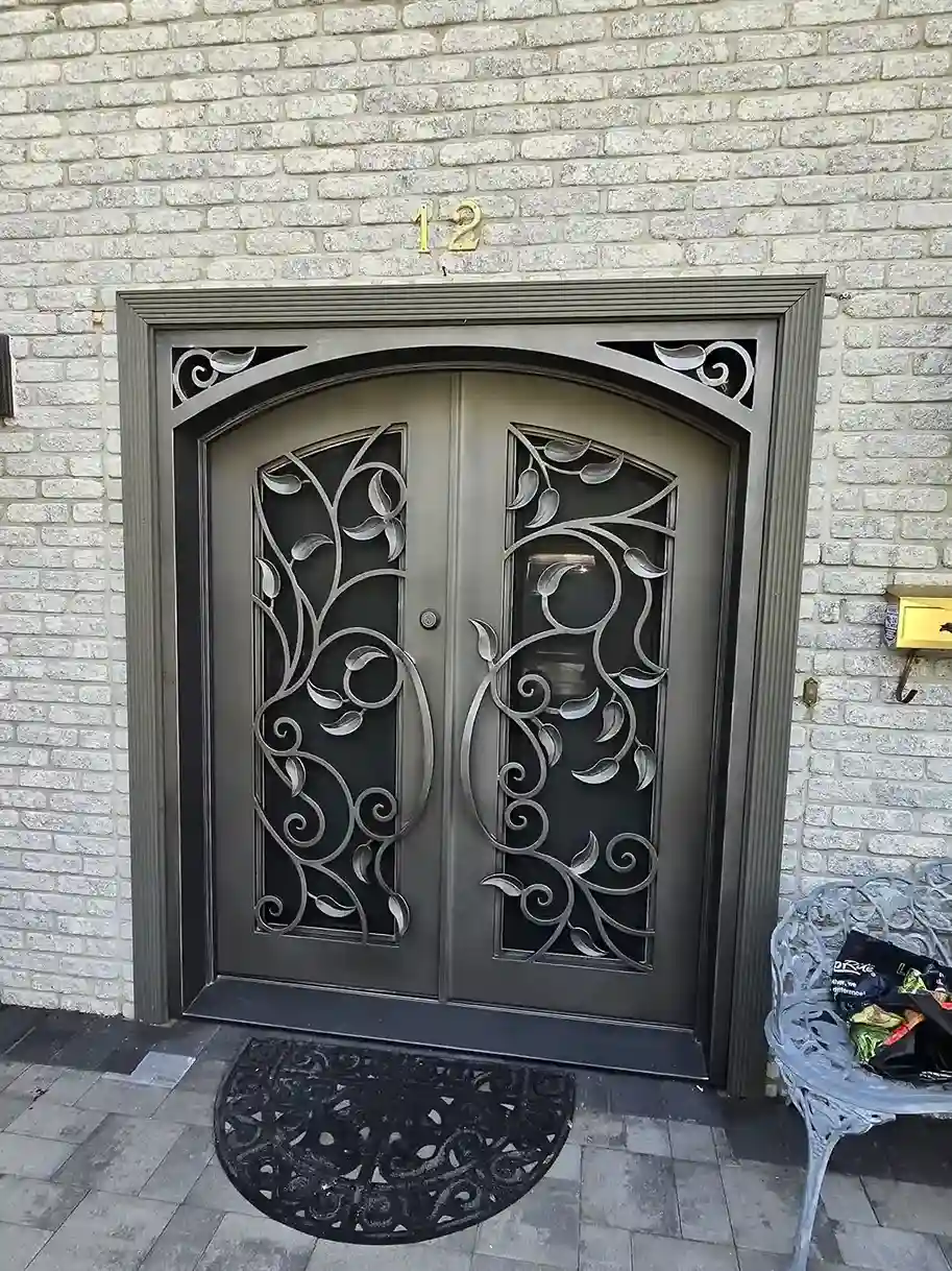 Custom wrought iron double entry door with floral scrollwork on brick home